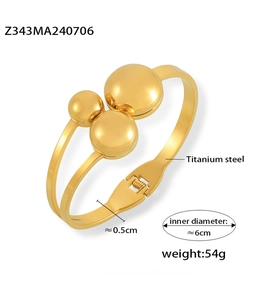 Detail of gold-plated titanium steel bangle showing metal balls and inner diameter size