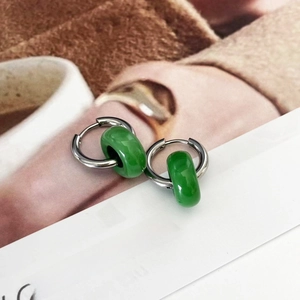 Close-up of green natural stone hoop earrings with a silver-toned metal finish