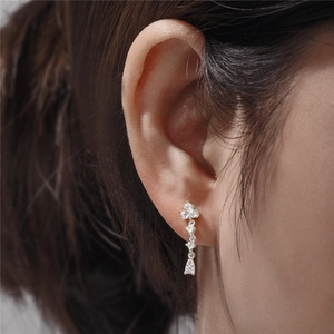 Detailed view of sterling silver drop earrings with zircons on a female model