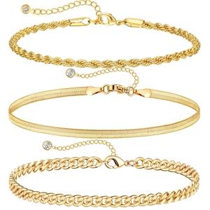 Detailed view of gold rope, herringbone, and cuban link bracelets with crystal charms