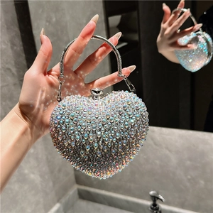 Macro view of heart-shaped evening bag with iridescent rhinestones and metal handle