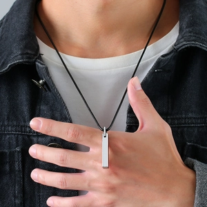 Close-up of a silver tungsten rectangular bar pendant with black cord chain on a male model
