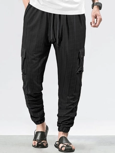 Detail of black waffle texture cargo pants with drawstring waist and cargo pockets
