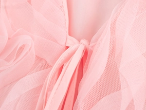 Gros plan du tissu en maille 3D rose montrant la dentelle plissée et le lien fin