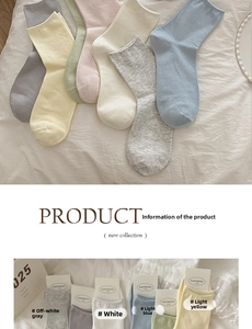 Detail of assorted pastel cotton knit crew socks on soft textured fabric background