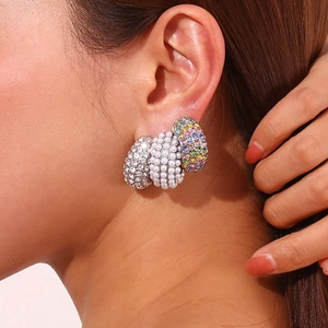 Detailed view of three-piece C-shape earrings with rhinestones, pearls and color gems