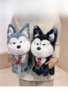 Close-up of soft plush husky dolls with collars and decorative tags held by a person