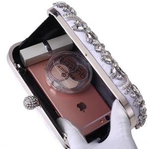 Close-up of white beaded evening bag showing capacity for lipstick, makeup, and smartphone