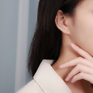 Minimalist S999 sterling silver heart and zircon stud earring set shown on model ear