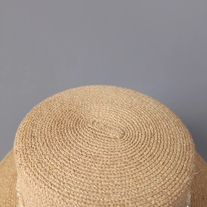 Vue détaillée du tissage fin en paille d'un chapeau de soleil élégant de style français