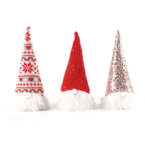 Three sequin knit faceless Christmas gnomes with glowing hats on white background
