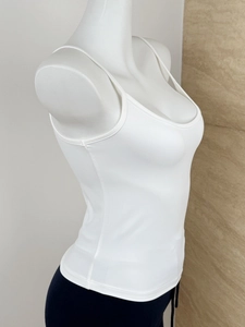 Side view of white slim-fit ribbed crop top tank on model with racerback detail