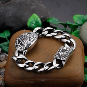 Retro stainless steel curb chain bracelet with cross relief and engraved clasp on rocks