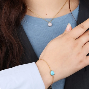 Close-up of elegant gold necklaces and bracelets set with colorful natural stone charms