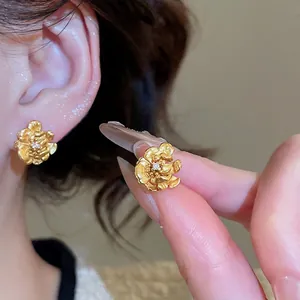 24K gold plated flower earrings with zircon center and matte finish on model