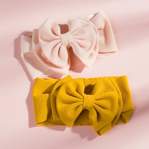 Detailed view of pink and yellow waffle knit texture on baby bow headbands