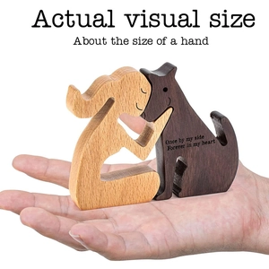 Hand-carved wooden dog memorial statue showing scale against a palm-sized hand