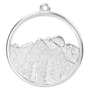 Macro shot of silver stainless steel pendant with mountain sun and forest engraving