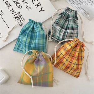 Detailed view of four colorful checkered drawstring pouches in cotton and linen fabrics