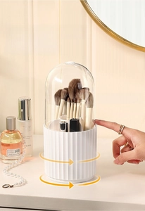 Close-up of a rotating white makeup organizer with a clear dustproof lid on a vanity table