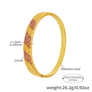 Detail of gold stainless steel bracelet with pink zircon and embossed grain texture
