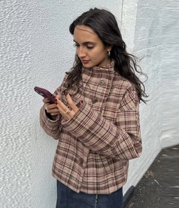 Close-up of brown checkered cropped jacket with stand collar and button details