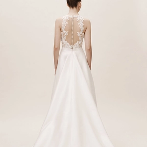 Elegant white satin wedding dress with intricate lace back and long trailing skirt