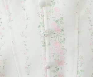 Gros plan sur tissu à fleurs avec boutons recouverts de tissu sur un chemisier