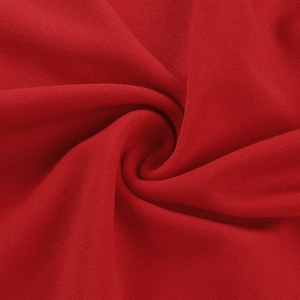Vue macro détaillée d'un tissu textile rouge doux montrant une texture fine et des plis