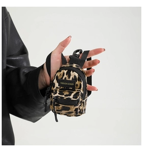 Mini leopard print backpack coin purse held in hand to show compact portable size