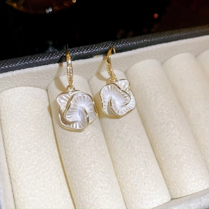 Macro shot of French style camellia earrings with white petals and sparkling cubic zirconia