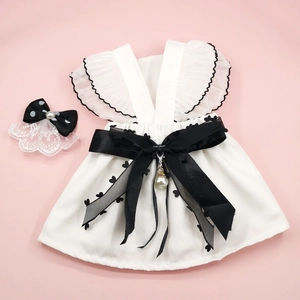 White pet wedding dress with black ruffles and pearl bow on a pink background