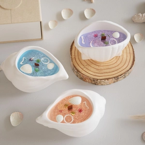 Detailed top view of sea shell shaped jelly candles with glitter, pearls and star charms