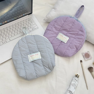 Detailed view of two quilted shell organizers for makeup and travel storage accessories