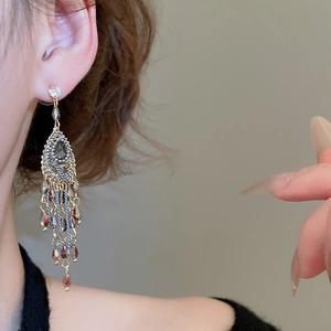 Detailed close-up of Bohemian drop earrings with crystal tassels and vintage metal design