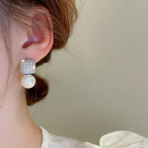 Detail of luxury zircon square pearl earrings worn by a model in French vintage style