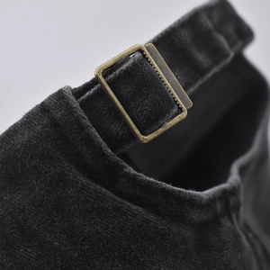 Close-up of black corduroy baseball cap back with bronze adjustable metal buckle