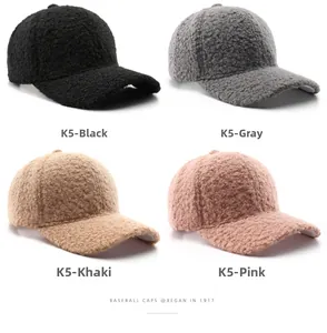 Dettaglio di berretti da baseball in pile bouclé nei colori nero, grigio, kaki e rosa