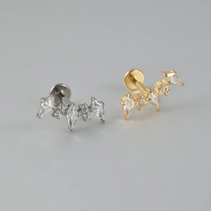 Close-up of F136 titanium lip studs with zircon flower clusters in gold and silver