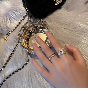 Detailed view of gold plated rhinestone rings on a luxury white plush background