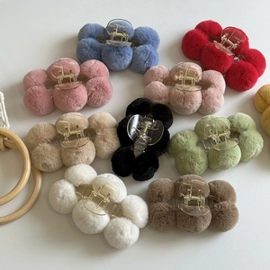 Multi-colored fluffy pom pom hair claws on white background for soft aesthetic hairstyles