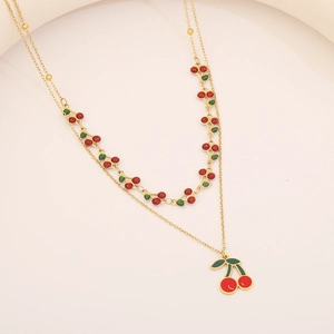 Détail d'un collier doré double rang avec pendentif cerise et perles rouges élégantes