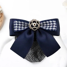 Detail of dark blue houndstooth hair clip with camellia ornament and snood net