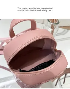Detail view of pink mini backpack interior with vintage monogram showing storage space