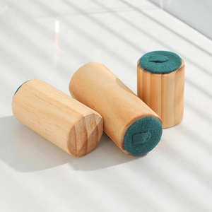 Three-piece solid wood ring display stands with green velvet tops in a soft natural light