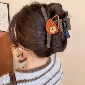 Detail of Korean knit bow hair claw featuring handmade crochet floral cup decoration