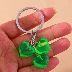 Detail showing three translucent emerald heart charms on a silver metal keychain