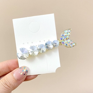 Close-up of mermaid tail hair clip with large crystals and iridescent rhinestones