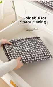 Detailed close-up of a foldable houndstooth storage bag being tucked into a drawer