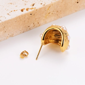 French style gold oval earrings with textured pearl inlay on a minimalist stone base